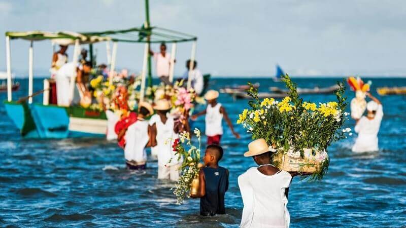 imagen de una de las Fiestas religiosas de Brasil: Iemanjá, feligreses llevan flores a su altar puesta en las agias del rio