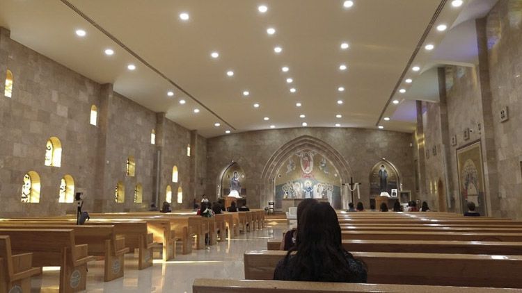 Interior de la Iglesia San Charbel en Chihuahua, con mural religioso detrás del altar