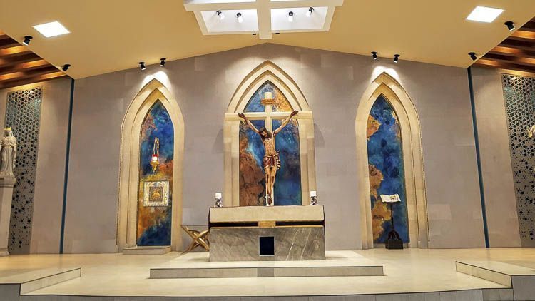 Altar moderno de la Parroquia de San Charbel en Saltillo, Coahuila, con crucifijo central y paneles decorativos