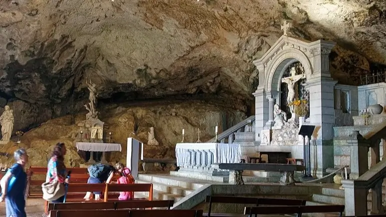 La imagen muestra el interior de la Gruta de Sainte-Baume, un importante lugar de peregrinación católica en la Provenza, Francia. 