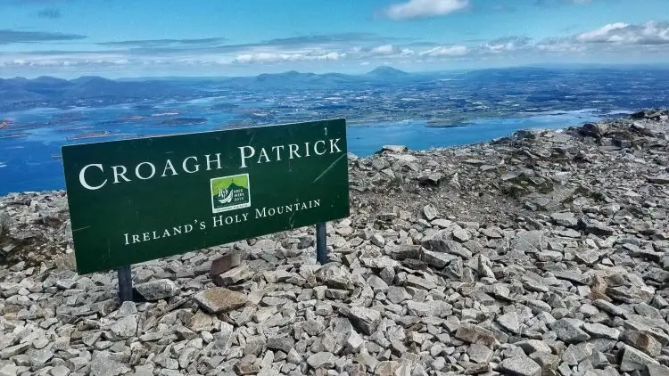 La imagen muestra la cumbre de Croagh Patrick (conocida localmente como The Reek), la montaña sagrada más famosa de Irlanda, ubicada en el condado de Mayo. Montañas sagradas