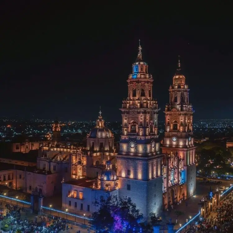 La imagen muestra una vista aérea nocturna de la Catedral de Morelia, una emblemática joya arquitectónica ubicada en el centro histórico de la ciudad de Morelia, Michoacán, México.