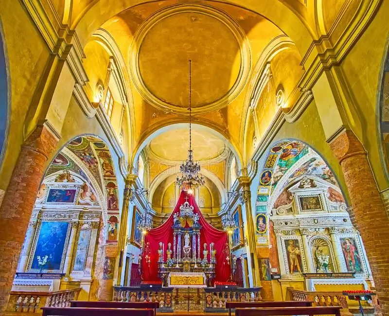 Altar barroco con candelabros, frescos y columnas ornamentadas en el interior de una iglesia histórica del canton de tesino, suiza