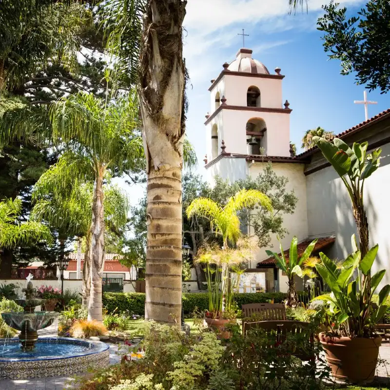 La imagen muestra el patio y el campanario de la Misión Basílica San Buenaventura en Ventura, California. 