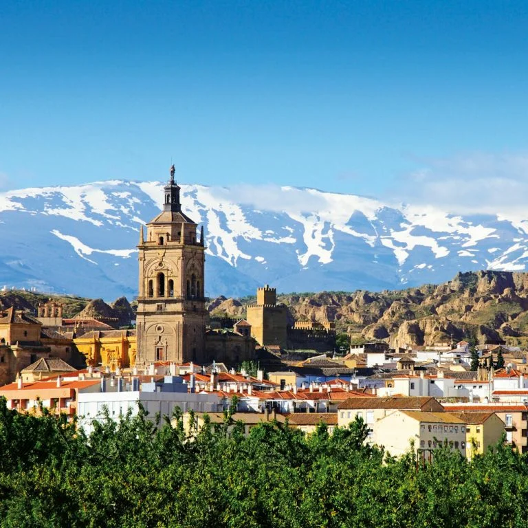 Esta imagen muestra la Catedral de Guadix en España, con su campanario renacentista destacando sobre la ciudad.