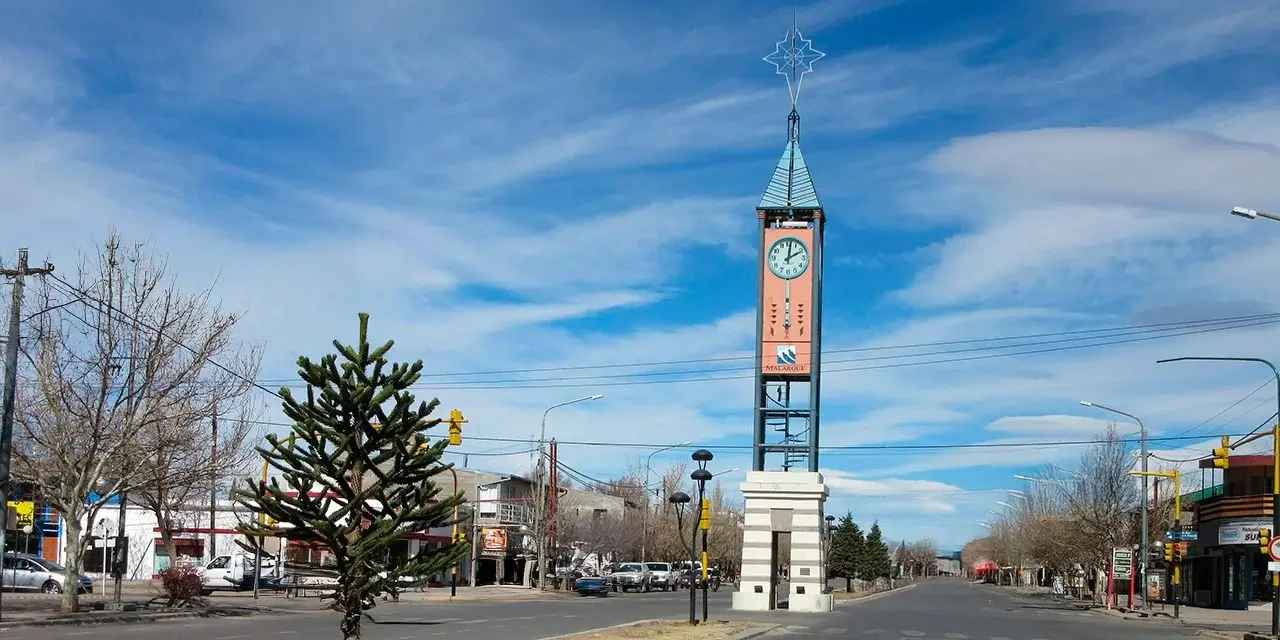 Esta fotografía muestra la Torre de las Horas en el centro de Malargüe, con su característico diseño de torre alta y cúpula adornada con una estrella. La estructura, inaugurada en 2000, se erige como un punto de referencia visual y cultural en la ciudad argentina.