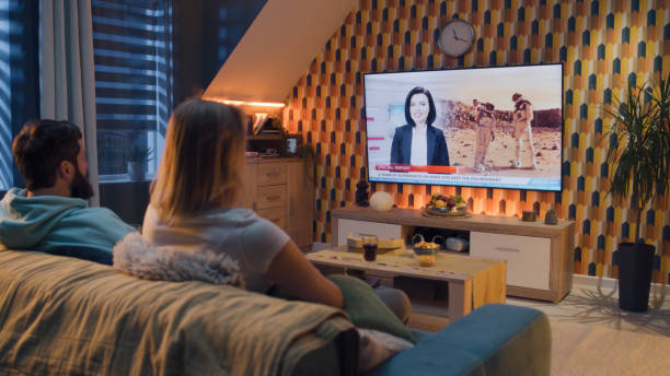 dos personas mirando la television