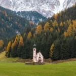 La imagen muestra la famosa iglesia de San Juan en Ranui (Chiesetta di San Giovanni in Ranui), un pequeño templo alpino situado en el norte de Italia