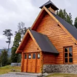 La imagen muestra la Capilla Nuestra Señora de Villa Traful, un templo de arquitectura rústica en madera y piedra ubicado en la provincia de Neuquén, Argentina
