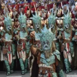 Esta fotografía captura a la comparsa cristiana de los Moros y Cristianos de Elda durante la entrada de la fiesta, con participantes vestidos de forma detallada y con máscaras y armaduras inspiradas en la época de las cruzadas. La celebración, que se desarrolla en mayo en Elda, es una de las más espectaculares de la provincia de Alicante y se celebra durante cinco días.