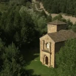 La imagen muestra la iglesia de Santa María de Iguácel, un destacado templo del románico aragonés del siglo XI situado en el fondo del valle de la Garcipollera, en la provincia de Huesca, España