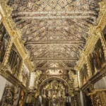 El interior de la Iglesia de San Pedro Apóstol de Andahuaylillas, en Cusco, Perú, destaca por su artesonado mudéjar policromado y sus muros cubiertos con pan de oro y pinturas murales coloniales, lo que le ha valido el apelativo de la "Capilla Sixtina de América"