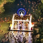 La imagen muestra la tradicional Embarcación de la Virgen de Alarilla, una procesión fluvial única que se celebra cada mes de septiembre en el río Tajo a su paso por el municipio de Fuentidueña de Tajo (Madrid, España). Esta singular tradición data de 1866 y cuenta con la participación de decenas de nadadores que acompañan a nado la barcaza iluminada de la patrona