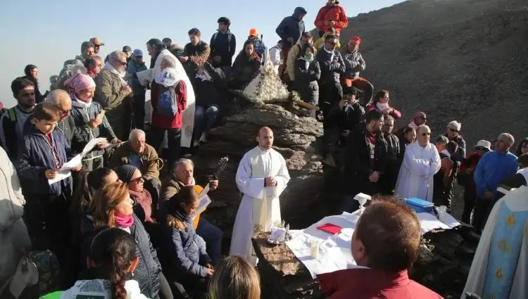 La imagen muestra la tradicional Romería Blanca de Pradollano a la Virgen de las Nieves en Sierra Nevada (Granada, España), considerada la romería católica que se celebra a mayor altitud en España (en torno a los 3.000 metros de altura, en los Tajos de la Virgen o cerca del Veleta)